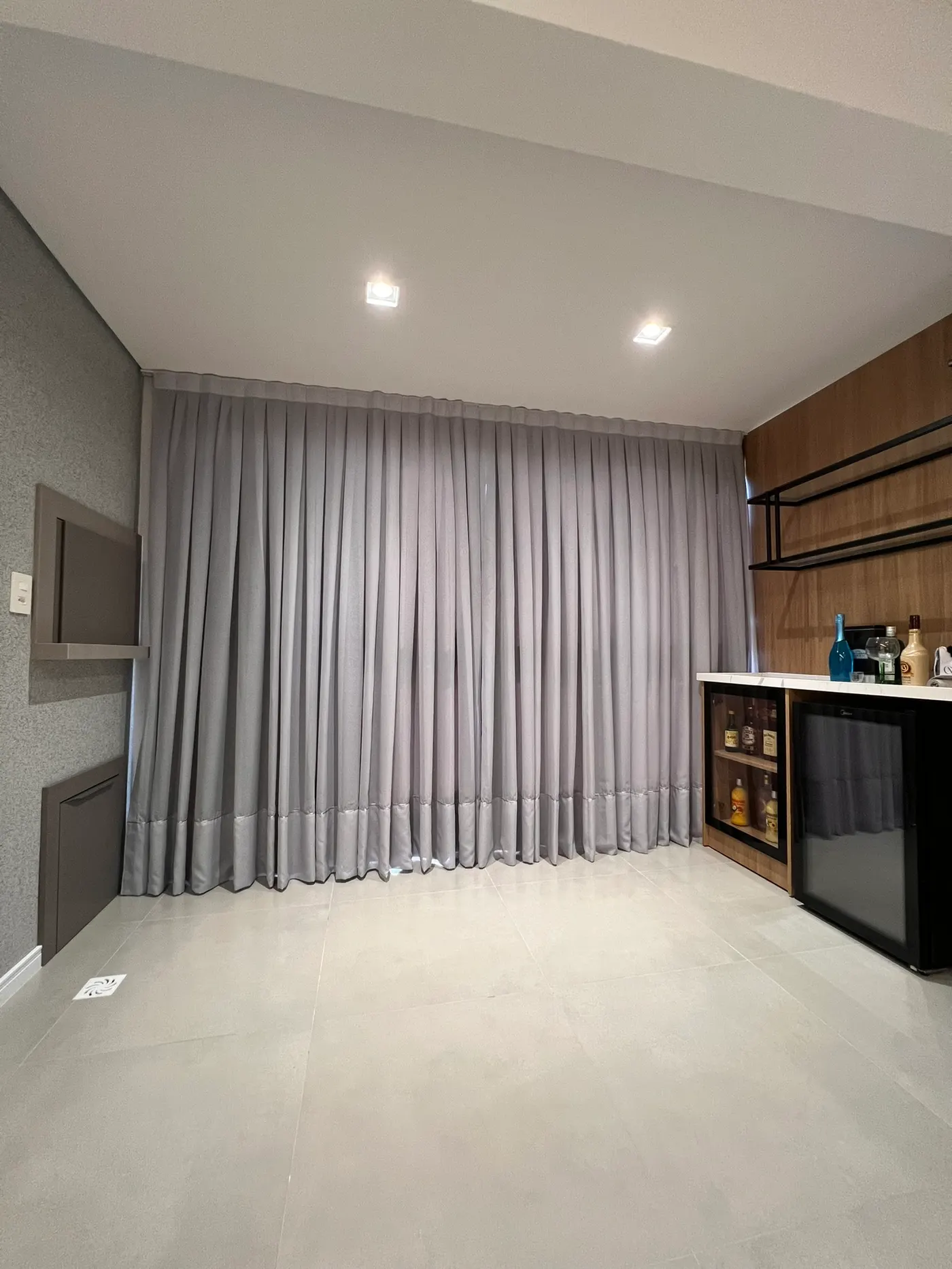 Sala com cortina cinza blackout e bar embutido