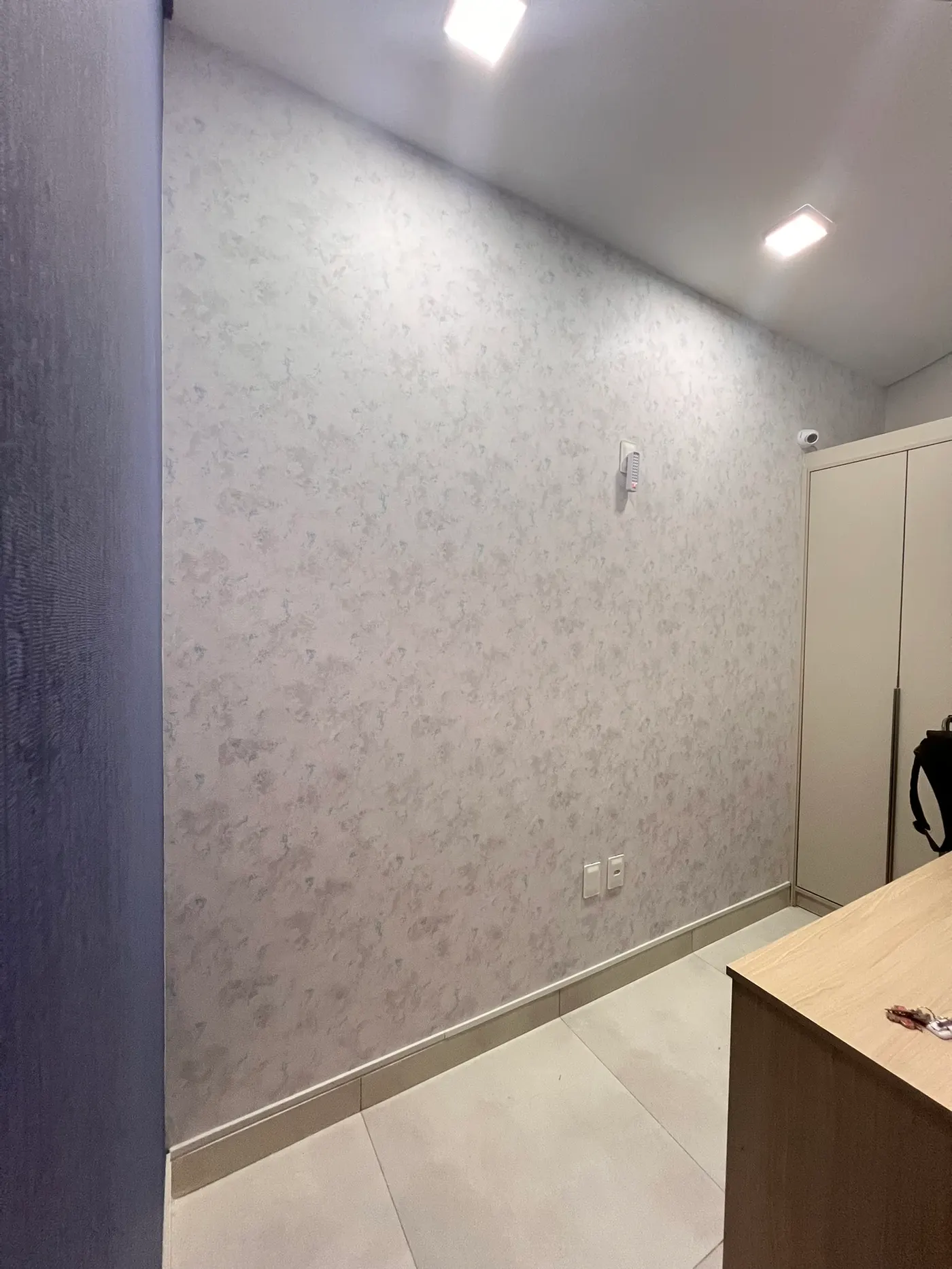 Parede com papel de parede texturizado em tons neutros