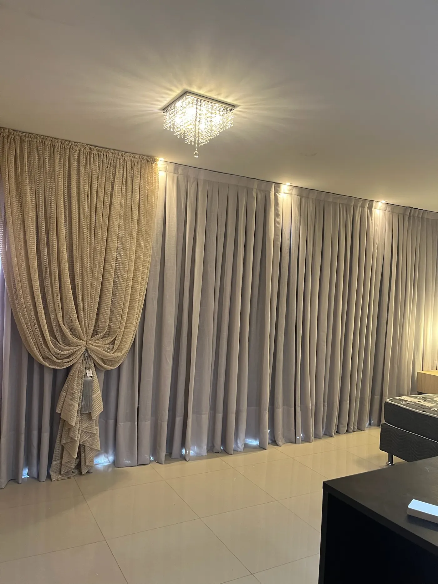 Sala com cortina bege e lustre de cristal