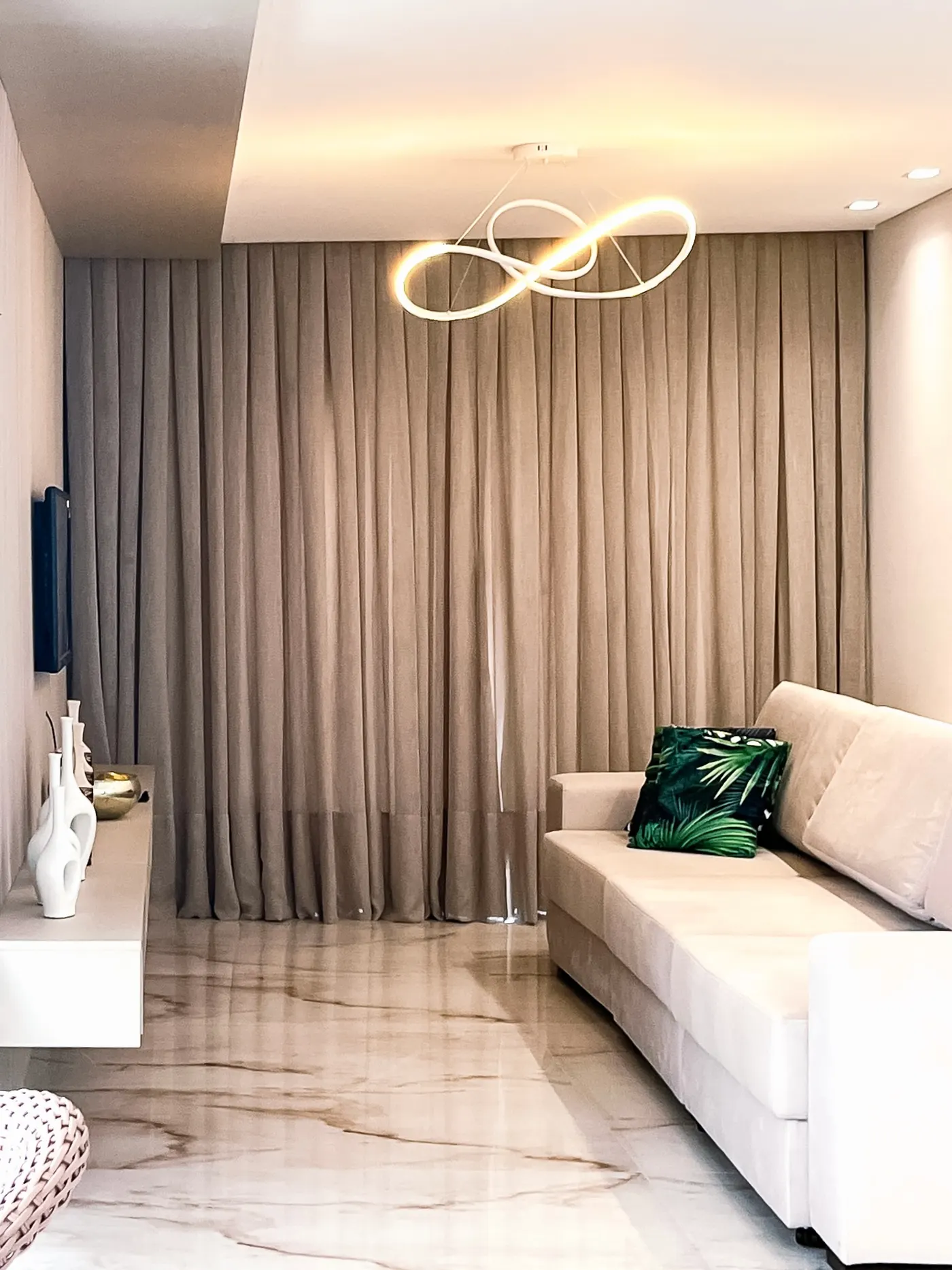Sala com cortina cinza e sofá branco