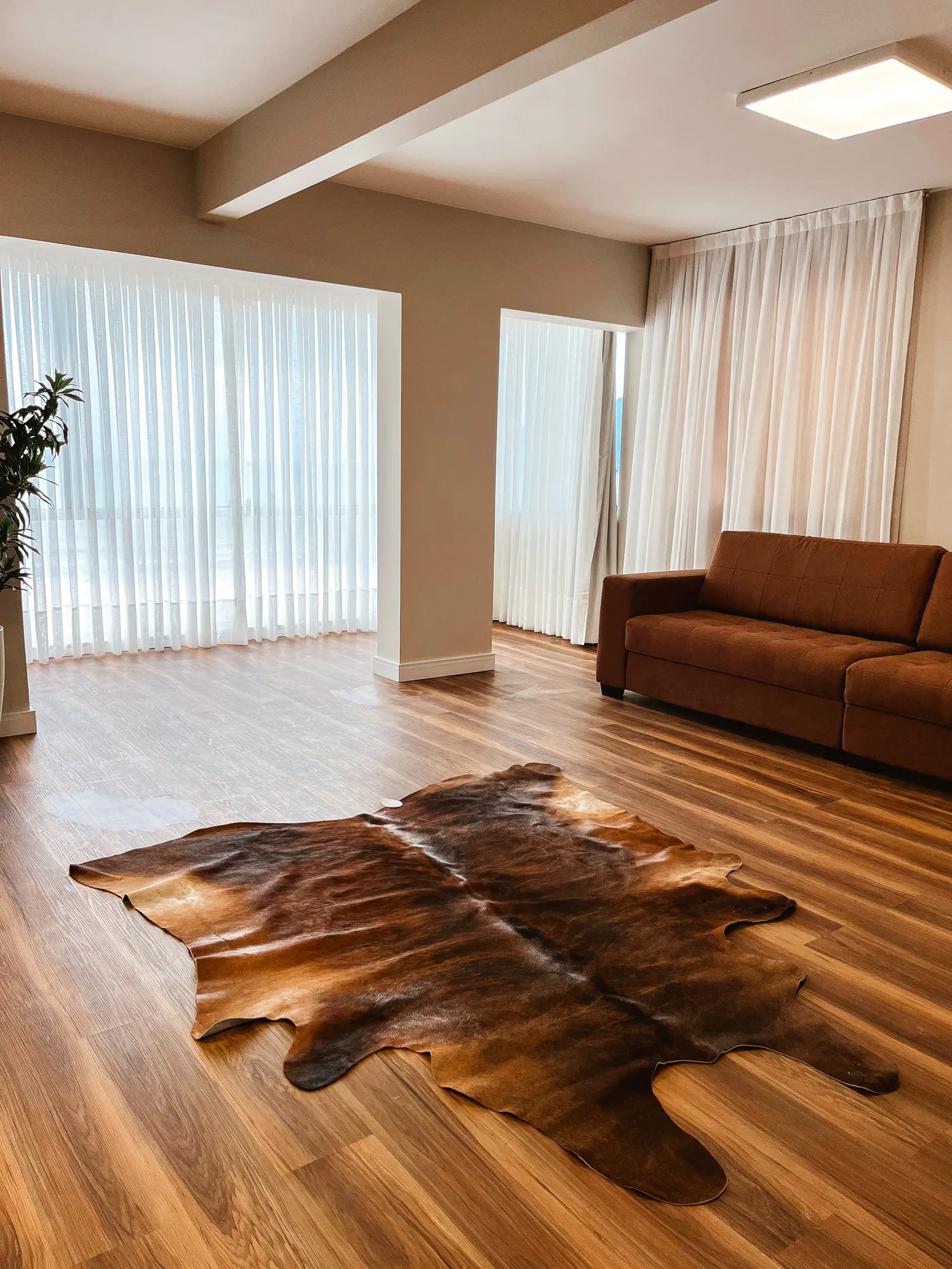 Sala com cortina de linho e tapete de couro
