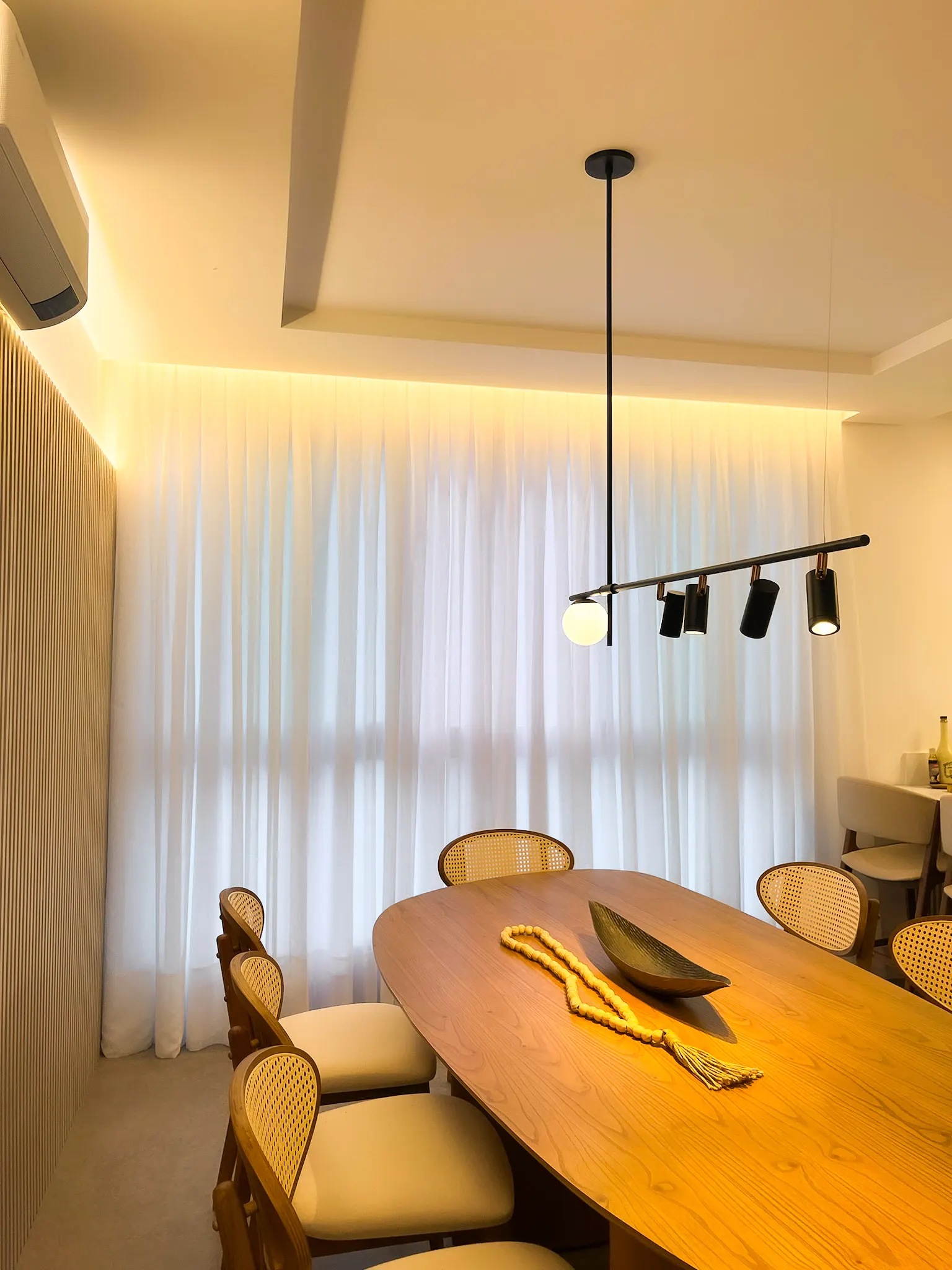Sala de jantar com cortina de voil branca e pendente